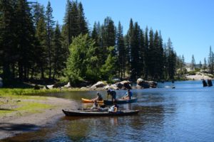 Candidate participants of White Stag Sierra paddle two canoes to the shore of Lake Sterling